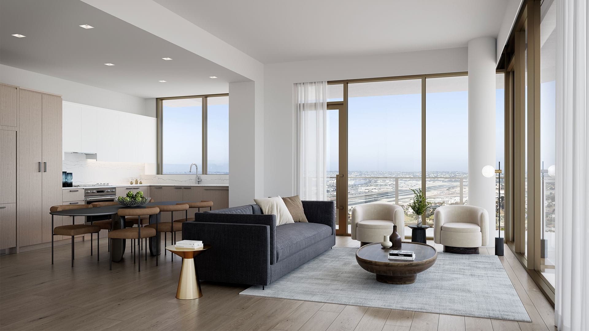Spacious and well lit living room with wood floors and large floor to ceiling windows with a city view.
