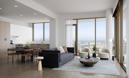 Spacious and well lit living room with wood floors and large floor to ceiling windows with a city view.