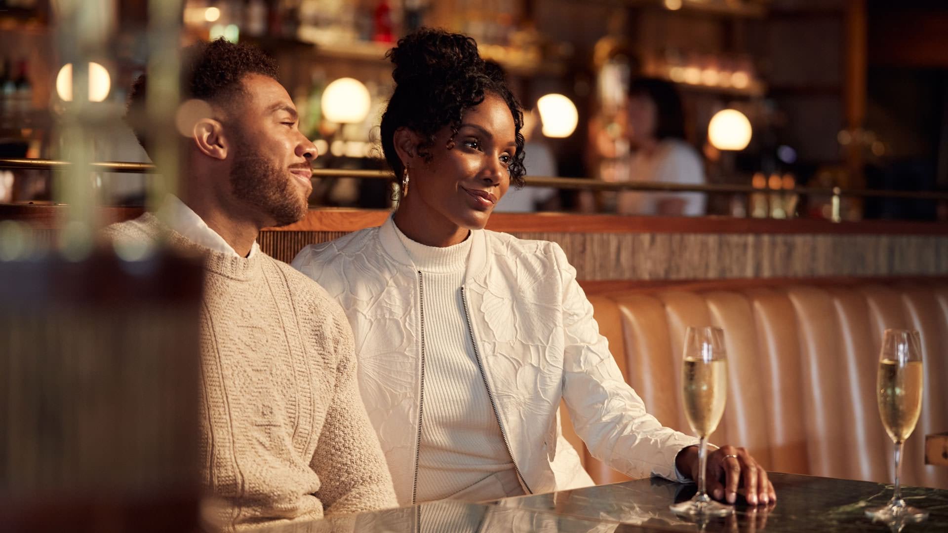Couple sitting in a elegant restaurant enjoying champagne